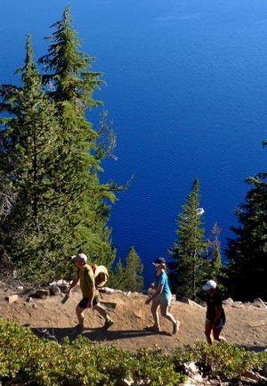 Hikers tread along the Cleetwood Cove Trail at Crater Lake in Oregon, a steep mile that winds to and from the shore.