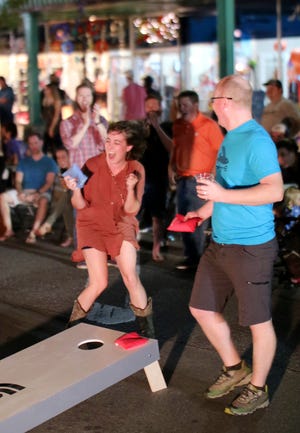 Briana Tobey, left, reacts to a toss as she and Sean Spence compete in the beanbag toss tournament during the last Heard on Hurd of the season. [Photo by Doug Hoke, The Oklahoman]