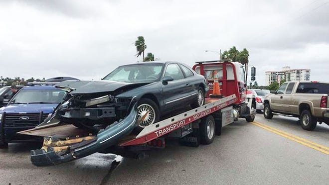 A 1996 Lincoln Continental sits on a tow truck after Palm Beach police said it rear-ended a City of West Palm Beach utilities truck on Thursday afternoon.