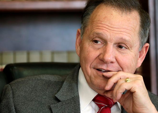 In this Oct. 24, 2012 file photo, former Chief Justice Roy Moore poses for a photo in his Montgomery, Ala., office.The attorney of Moore says three of his client's law clerks have been fired.