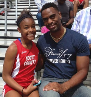 Trinity Gay, a seventh-grader racing for her Scott County High School team, poses for a photo with her father Tyson Gay, on May 3, 2014 after she won the 100 meters at a meet in Georgetown, Ky. The 15-year-old daughter of Olympic sprinter Tyson Gay was fatally shot in the neck, authorities and the athlete's agent said Sunday. MARK MALONEY / AP