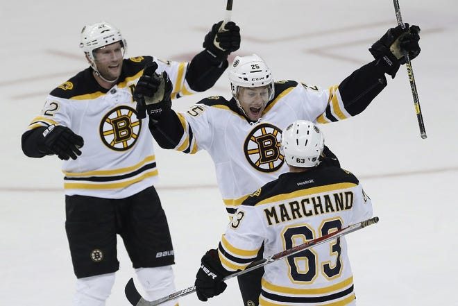 With David Backes, left, and Brad Marchand, right, Boston's Brandon Carlo celebrates his first NHL goal on Monday night.