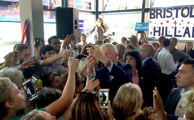 Former President Bill Clinton (center) stops to take a selfie with some of the Democratic Party faithful gathered at Hillary Clinton's campaign headquarters in Bristol Borough Tuesday, Oct. 18, 2016, after a quick get-out-the-vote speech. Clinton made the "unannounced" stop in Bucks County before heading to a campaign speech at Montgomery County Community College.