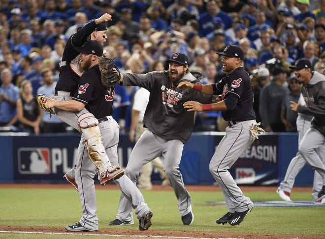Cleveland Indians relief pitcher Cody Allen (37), catcher Roberto Perez (55) and teammates Andrew Miller and Coco Crisp celebrate the team's victory over the Toronto Blue Jays during Game 5 of the baseball American League Championship Series in Toronto on Wednesday. (Nathan Denette/The Canadian Press via AP)