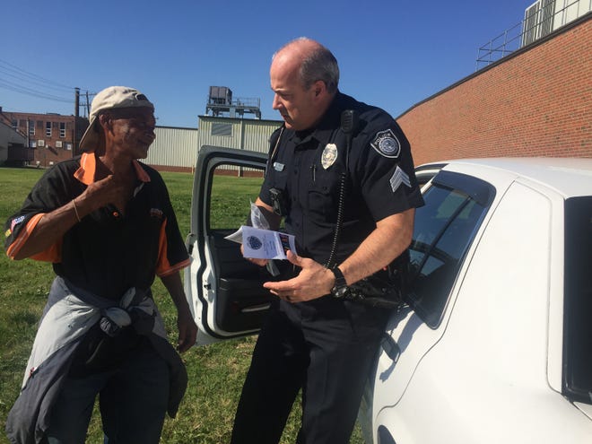 Donell Wilson, left, speaks with Burlington Police Sgt. Sam Epps on Wednesday as he receives a reflective bracelet and brochure on pedestrian safety. NATALIE ALLISON JANICELLO / TIMES-NEWS