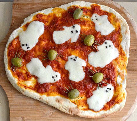 Fresh olives mozzarella and black olives create spooky floating ghosts on this pizza.