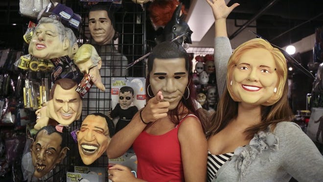 Tanairi Rivera (left, age 20) of Loxahatchee and Monica Herrera (age 22) of Jupiter try on masks of President Obama and Hillary Clinton at Halloween Express in The Mall at Wellington Green. “I’ve always wanted a picture wearing the mask of my favorite Presidential candidate,” said Herrera. “I am praying she wins. She has so much more knowledge and experience.” (Bruce R. Bennett / The Palm Beach Post)