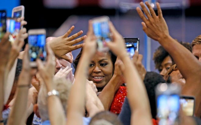 Supporters wave and take photographs of first lady Michelle Obama after she spoke at a campaign rally for Democratic presidential candidate Hillary Clinton Thursday, Oct. 20, 2016, in Phoenix. (AP Photo/Ross D. Franklin)