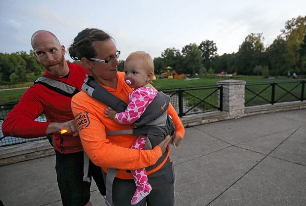 John Forsberg secures the baby carrier for his wife, Daelynn, and daughter Pyper, 1, before the Hike It Baby outing at Hannah Park.