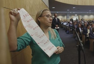 Carmen Balber, executive director of Consumer Watchdog, displays a roll of toilet paper at the Capitol in Sacramento, Calif., as a prop to say the proposed regulations for self-driving cars are paper-thin. AP/Rich Pedroncelli