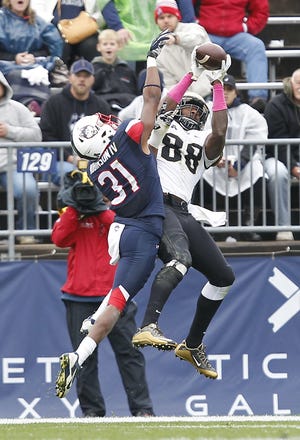 UCF's Jordan Akins (88) catches a touchdown pass over the defense of UConn's John Robinson IV during the second quarter Saturday in East Hartford, Connecticut. ASSOCIATED PRESS/STEW MILNE
