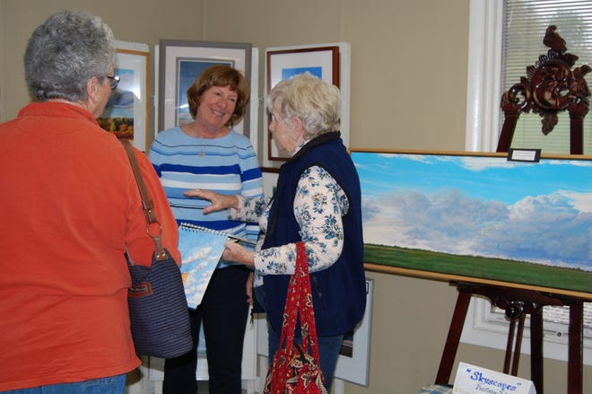 Featured artist Lanna Pendleton Hall (center) talks with visitors at the Art Guild exhibit Thursday. NANCY HASTINGS PHOTO