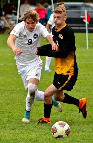 Samuel Brady, of Hillsdale Academy, competes with a Lansing Christian player for control of the ball. ANDREW KING PHOTO