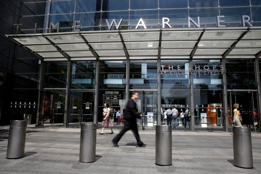 FILE - In this Tuesday, May 26, 2015 file photo, pedestrians walk by an entrance to the Time Warner Center in New York. On Saturday, Oct. 22, 2016, several reports citing unnamed sources said AT&T is in advanced talks to buy Time Warner, owner of the Warner Bros. movie studio as well as HBO and CNN. The giant phone company is said to be offering $80 billion or more, a massive deal that would shake up the media landscape. (AP Photo/Mary Altaffer)