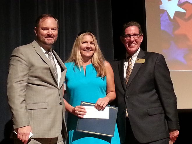 Heritage Middle School teacher Lisa Paige Bynum received the Superintendent's Creative Mini-Grant Award from Superintendent Tom Russell, right, and Futures President John Guthrie, left. Photo provided
