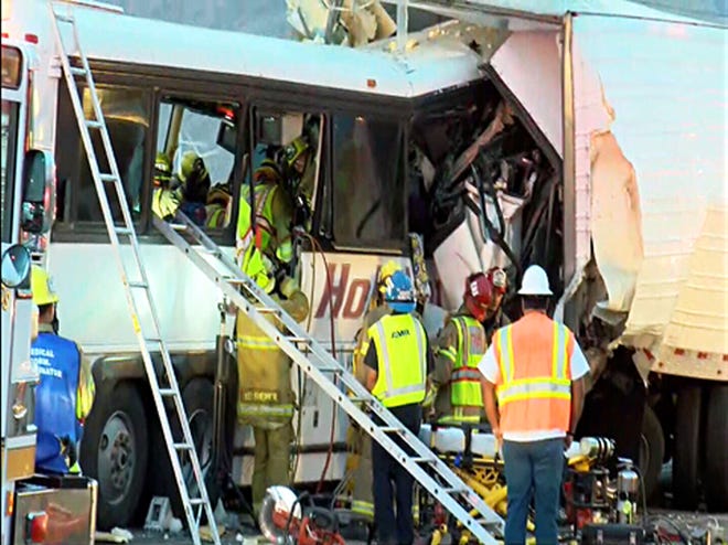 This photo provided by KESQ News Channel 3/CBS Local 2 shows the scene of crash between a tour bus and a semi-truck on Interstate 10 in Desert Hot Springs, near Palm Springs, in California's Mojave Desert Sunday, Oct. 23, 2016. Multiple deaths and injuries were reported. (KESQ NewsChannel 3/CBS Local 2 via AP)