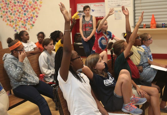 Girls Inc. students raise their hands to be involved in a mock voting exercise Friday with lobbyist Olivia Crosby. HEATHER HOWARD/The News Herald