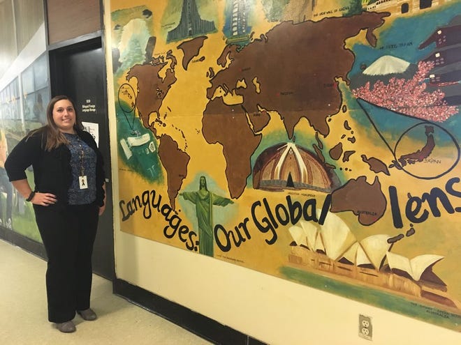 Foreign language coordinator Rachael Umbrianna, who is heading the new biliteracy certification program at Brockton High, shows off a student mural promoting language learning.