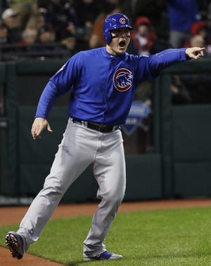 The Chicago Cubs' Anthony Rizzo points to Kyle Schwarber after scoring on a hit during the third inning of Game 2 of the World Series on Wednesday. THE ASSOCIATED PRESS