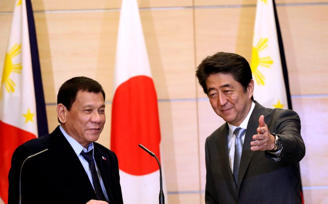 Philippine President Rodrigo Duterte, left, is shown the way by Japanese Prime Minister Shinzo Abe after a joint press conference following their meeting at Abe's official residence in Tokyo, Wednesday, Oct. 26, 2016. (AP Photo/Eugene Hoshiko, Pool)