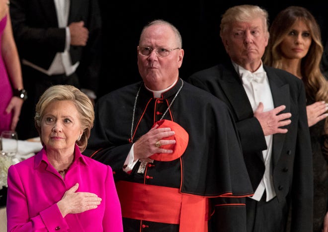 From left, Democratic presidential candidate Hillary Clinton; Cardinal Timothy Dolan, Archbishop of New York; Republican presidential candidate Donald Trump, and his wife Melania Trump, stand for the Star Spangled Banner at the 71st annual Alfred E. Smith Memorial Foundation Dinner, a charity gala organized by the Archdiocese of New York on Oct. 20, 2016, at the Waldorf Astoria hotel in New York.