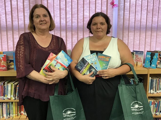 Julie Chiello (left), librarian at the Oak Hill library, and Jeanette Dase, president of the Friends of the Library, recently presented new Sunshine State readers to the library at Burns Science & Technology Charter School.