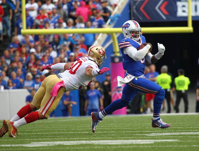 Buffalo Bills quarterback Tyrod Taylor, right, eludes San Francisco 49ers linebacker Nick Bellore during the second half of an NFL football game on Sunday, Oct. 16, 2016, in Orchard Park, N.Y.