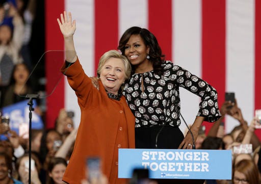 Democratic presidential candidate Hillary Clinton, accompanied by first lady Michelle Obama, greet supporters during a campaign rally in Winston-Salem, N.C., Thursday, Oct. 27, 2016. (AP Photo/Chuck Burton)