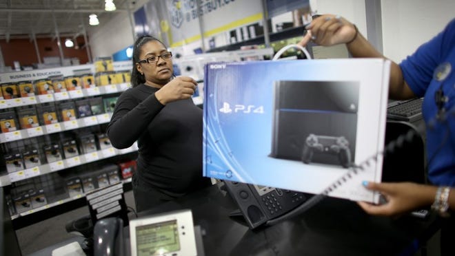 PEMBROKE PINES, FL - NOVEMBER 15: Kimberly Lee purchases a Sony Playstation 4 at Best Buy after they went on sale at midnight on November 15, 2013 in Pembroke Pines, Florida. PlayStation 4 is the follow-up to the company's PlayStation 3 and is priced at $400. (Photo by Joe Raedle/Getty Images)