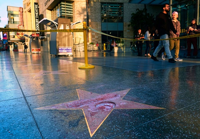 Pedestrians walk past a cordoned off area surrounding the vandalized star for Republican presidential candidate Donald Trump on the Hollywood Walk of Fame, Wednesday, Oct. 26,2016, in Los Angeles. Det. Meghan Aguilar said investigators were called to the scene before dawn Wednesday following reports that Trump’s star was destroyed by blows from a hammer. (AP Photo/Richard Vogel)
