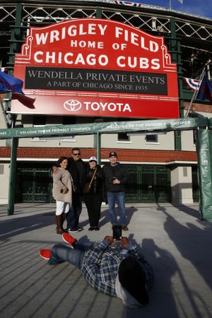 Fans gather in front of the marquee at Wrigley Field in Chicago for a picture on Thursday. The ballpark will host its first World Series game since 1945 when it hosts Game 3 of the World Series between the Chicago Cubs and the Cleveland Indians on Friday. Associated Press