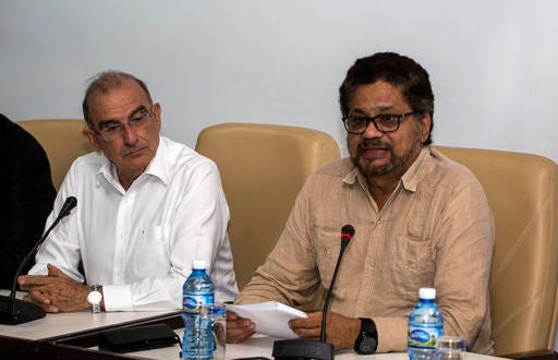 Humberto de La Calle, left, head of Colombia's government peace negotiation team, listens as Ivan Marquez, chief negotiator of the Revolutionary Armed Forces of Colombia (FARC) reads a joint statement in Havana, Cuba, Friday, Oct. 28, 2016. The statement said many new proposals have been incorporated in the text of a new peace accord after voters narrowly defeated the deal on Oct. 2. (AP Photo/Desmond Boylan)