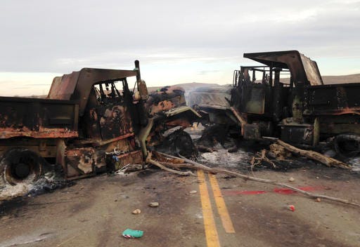 The burned hulks of heavy trucks sit on Highway 1806 near Cannon Ball, N.D., on Friday, Oct. 28, near the spot where protesters of the Dakota Access pipeline were evicted from private property a day earlier. Authorities say protesters burned several pieces of construction equipment Thursday during a chaotic confrontation with law enforcement. (AP Photo/James MacPherson)