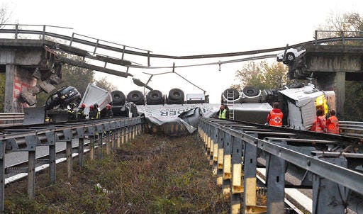 A truck lies on a road after an overpass it was traveling on collapsed, between Milan and Lecco, northern Italy, Friday, Oct. 28, 2016. An overpass north of Milan has collapsed under the weight of a truck carrying an over-size load just hours after highway authorities say they requested the road’s immediate closure. (Fabrizio Cusa/ANSA via AP)