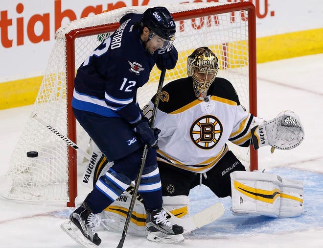 Winnipeg Jets' Drew Stafford's deflects the puck against Boston Bruins goaltender Tuukka Rask during first period NHL action in Winnipeg, Manitoba, Monday, Oct. 17, 2016.