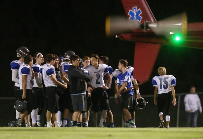 Teammates of New Life Christian School's Christian Arrington look on as he is transported to a hospital by NorthFlight following an injury in the second quarter of a game against Tuscaloosa Christian School on Friday. The game was called following Arrington's transport, with Tuscaloosa Christian ahead 42-0. Staff Photo/Erin Nelson