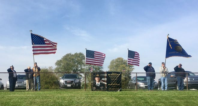 Members of the Roy Miller Post 644 American Legion salute the funeral procession of Sgt. Douglas Riney who died Oct. 19 of wounds received after encountering hostile enemy forces in Kabul, Afghanistan.
