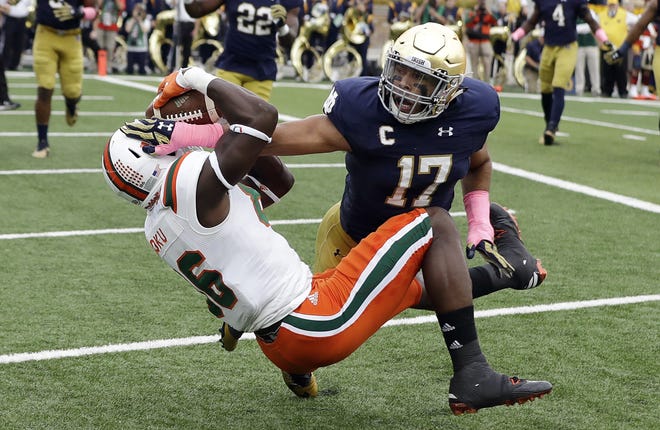 Miami 's David Njoku (86) makes 2-yard touchdown reception while defended by Notre Dame 's James Onwualu on Saturday. THE ASSOCIATED PRESS/DARRON CUMMINGS