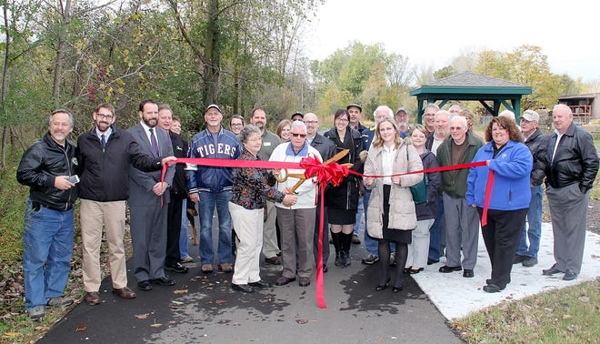Don and Donna Playford (center) snip the ribbon officially opening the Rail Trail in Jonesville Thursday. Although the trail has been open since late summer an official ribbon cutting was held on Thursday. ANDY BARRAND PHOTO