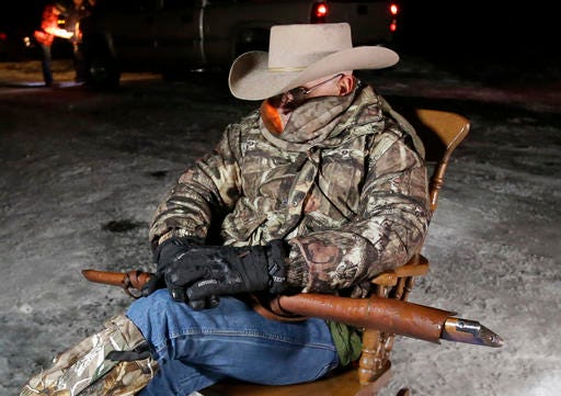 FILE - In this Jan. 5, 2016, file photo, Arizona rancher LaVoy Finicum, holds a rifle as he guards the Malheur National Wildlife Refuge near Burns, Ore. The stunning acquittal of seven people who occupied a federal bird refuge in Oregon as part of a Western land dispute was a rejection of the prosecution’s conspiracy case, not an endorsement of the armed protest, a juror said Friday, Oct. 28, 2016. (AP Photo/Rick Bowmer, File)