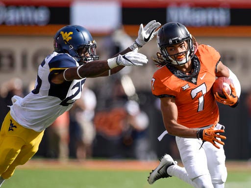 Oklahoma State's Ramon Richards (7) runs from West Virginia's Justin Crawford, as he returns an interception 59-yards during the second half of an NCAA college football game in Stillwater, Okla., Saturday, Oct. 29, 2016. Oklahoma State defeated West Virginia 37-20. (AP Photo/Brody Schmidt)