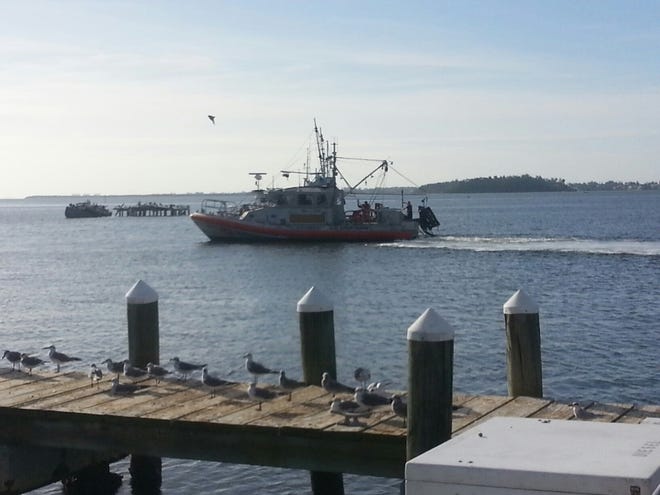 A 45-foot Response Boat-Medium boat crew from Coast Guard Station Cortez tows a 40-foot fishing boat to A.P. Bells Seafood in Cortez on Saturday. The Coast Guard crew rescued two men after the boat took on water 13 miles west of Anna Maria Island. PHOTO COURTESY OF U.S. COAST GUARD