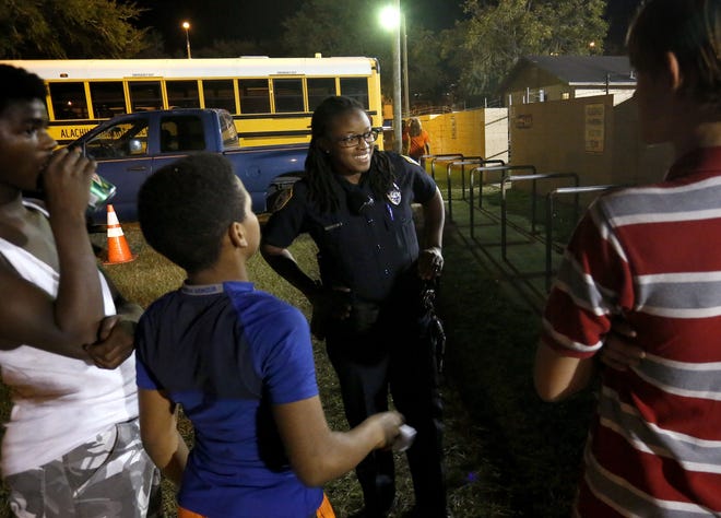Officer Marquitta Brown, with the Gainesville Police Department's gang unit, talks recently with a group of youths outside Citizen's Field during a football game in Gainesville. Due to a recent rise in gang activity, GPD has decided to add another officer to the gang unit. Brad McClenny/GateHouse Media Florida