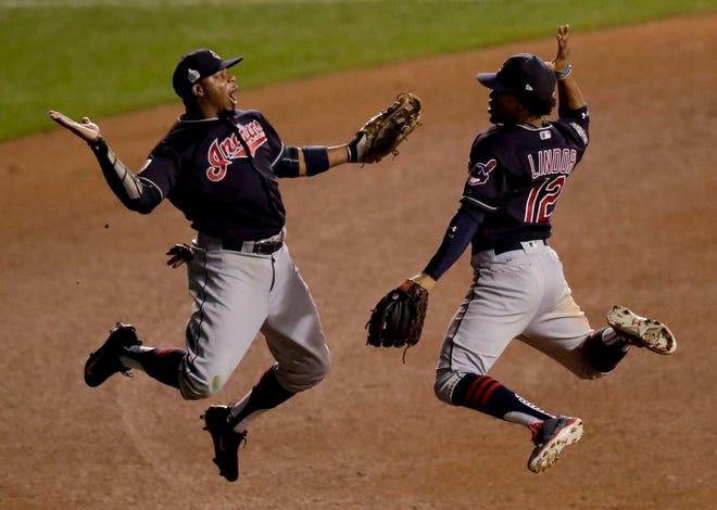 Cleveland Indians left fielder Rajai Davis, left, and shortstop Francisco Lindor celebrate their win after Game 4 of the World Series against the Chicago Cubs Saturday night. The Indians won 7-2 to take a 3-1 lead in the series. (AP Photo/Charles Rex Arbogast)