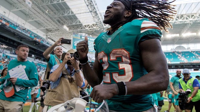 Miami Dolphins running back Jay Ajayi (23) runs off the field after his second 200 yard plus rushing game at Hard Rock Stadium in Miami Gardens, Florida on October 23, 2016. (Allen Eyestone / The Palm Beach Post)