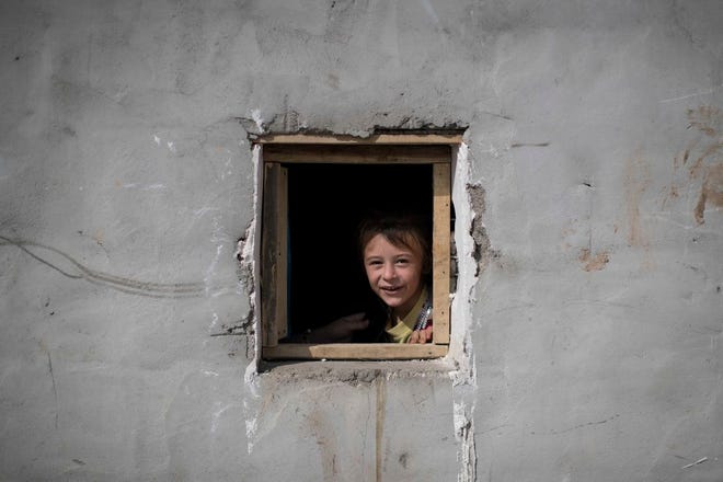 A girl looks out of the window of her home in the Yahyawa camp for internally displaced Turkmen on the outskirts of Kirkuk, Iraq, Sunday, Oct. 30, 2016. Over 600 families from Tel Afar, a town west of Mosul, have been living in the camp for two years and are hoping for their town to be liberated from Islamic State militants so they can return to their homes. (AP Photo/Felipe Dana)