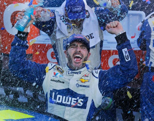 Jimmie Johnson celebrates after winning the NASCAR Sprint Cup Series auto race at Martinsville Speedway in Martinsville, Va., Sunday, Oct. 30, 2016. (AP Photo/Steve Helber)