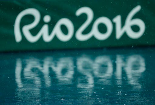 FILE - In this Aug. 15, 2016 file photo, the Olympic logo is reflected on the wet floor as the athletics competitions of the Summer Olympics are suspended due to the pouring rain in Rio de Janeiro, Brazil. Workers employed at the Rio Olympics are ready to sue the organizing committee for late payments more than 2 1/2 months after the problem-filled games ended. (AP Photo/Matt Slocum, File)