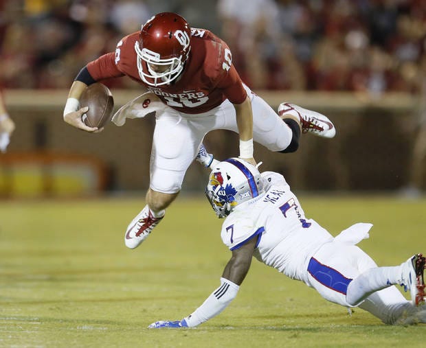 Kansas' Derrick Neal upends OU backup quarterback Austin Kendall in the Sooners' 56-3 victory on Saturday night. (Photo by Bryan Terry)