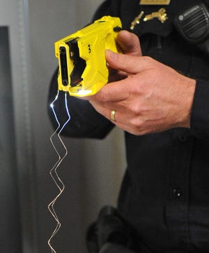 East Bridgewater police Sgt. Mike McLaughlin fires two TASER barbs guided by a laser into a target in the station on Monday, January 14, 2013.